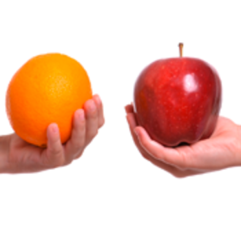 Ein Apfel und eine Orange werden vor weißem Hintergrund gegenüber gehalten